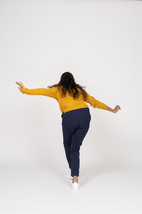 Vue postérieure, de, a, girl, dans, vêtements décontractés, poser, à, bras tendus