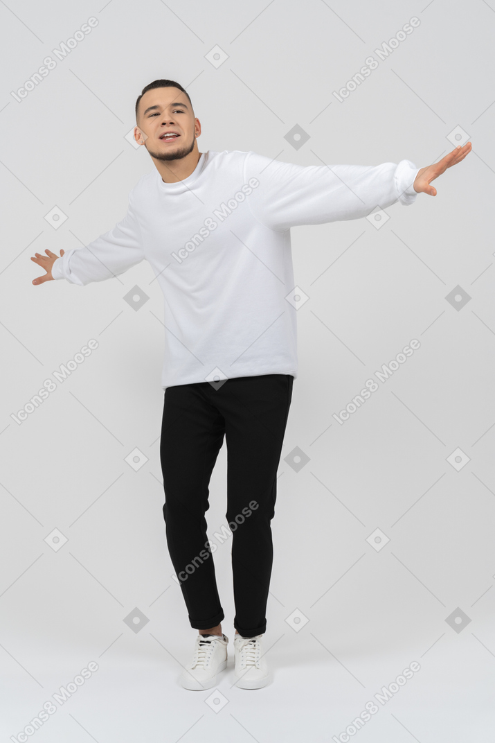 Jeune homme debout les bras tendus