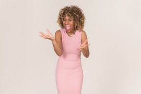 A woman in pink dress standing with closed eyes and yelling