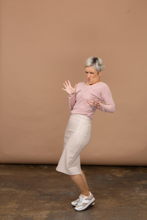 Side view of an emotional woman in casual clothes showing stop gesture